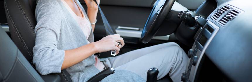 Image of a young girl wearing seat belt before start driving