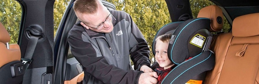 Father doing his son car seat belt